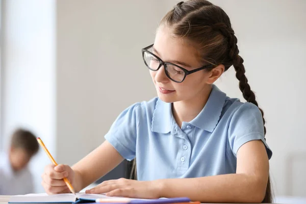 Schattig klein meisje tijdens les in klaslokaal — Stockfoto