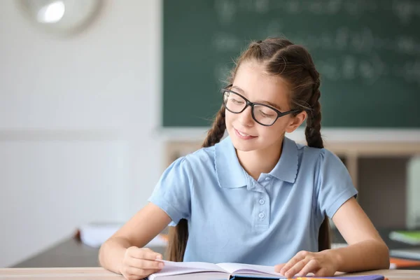 Menina bonito durante a aula em sala de aula — Fotografia de Stock