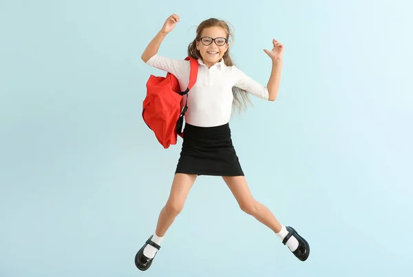 Salto piccola studentessa su sfondo di colore — Foto Stock