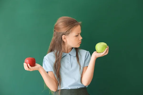 Gadis sekolah kecil dengan apel di latar belakang warna — Stok Foto