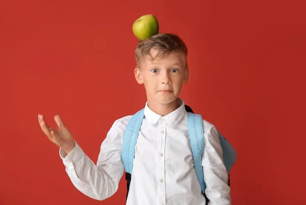 Little schoolboy with apple on color background — Stock Photo, Image