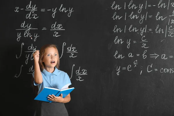 Little schoolgirl near blackboard in classroom — Stock Photo, Image