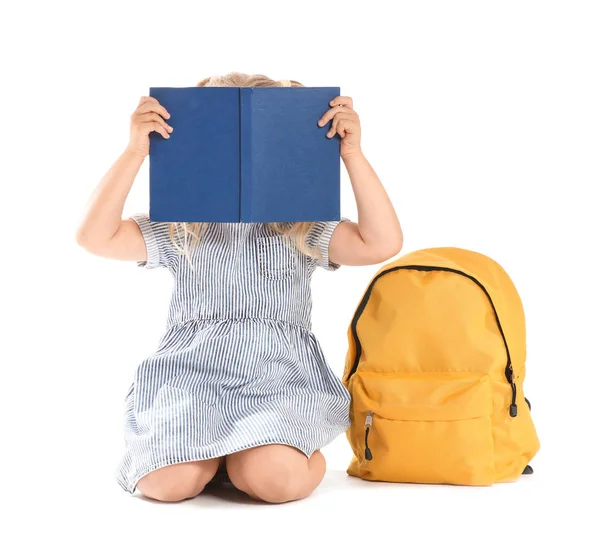 Söt liten skolflicka med bok och ryggsäck på vit bakgrund — Stockfoto