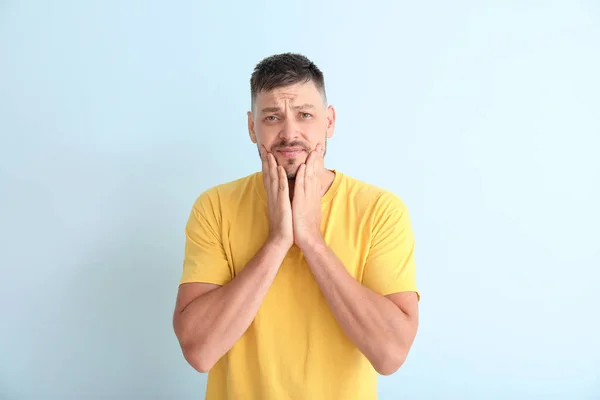 Man suffering from toothache against color background — Stock Photo, Image