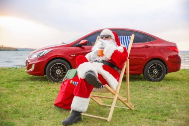 Serin Noel Baba nehir kenarında dinleniyor kokteyl ile