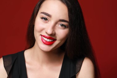 Renk arka planında parlak ruj olan güzel genç bir kadın.