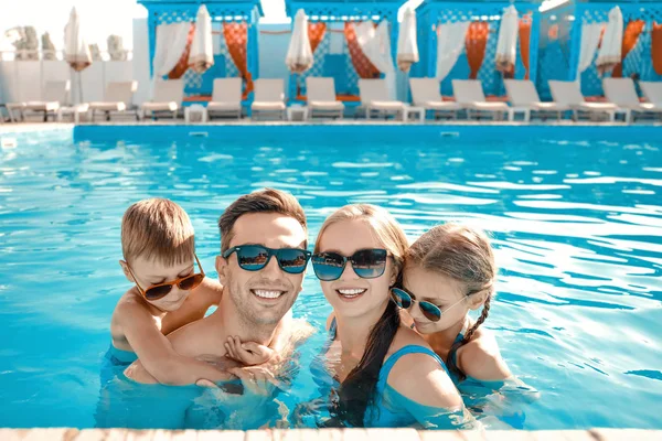 Happy family in swimming pool on summer day — Stock Photo, Image