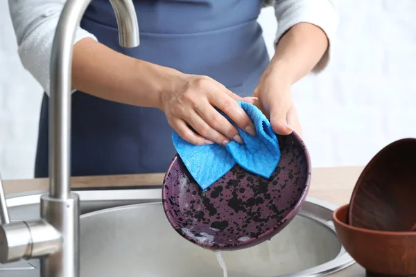 Woman washing dishes in kitchen sink — Stock Photo, Image