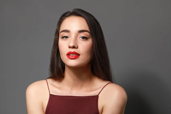 Beautiful young woman with bright lipstick on grey background — Stock Photo, Image