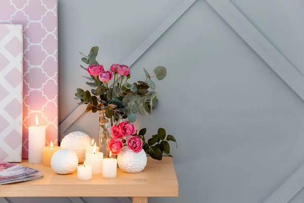 Belle candele ardenti e mazzo di fiori sul tavolo in camera — Foto Stock