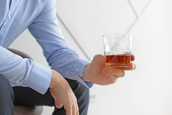 Man with glass of whiskey at home