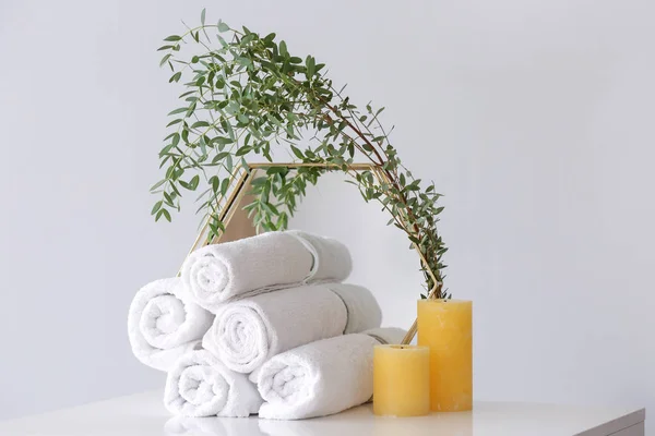Limpiar toallas suaves, espejo y velas en la mesa en la habitación —  Fotos de Stock