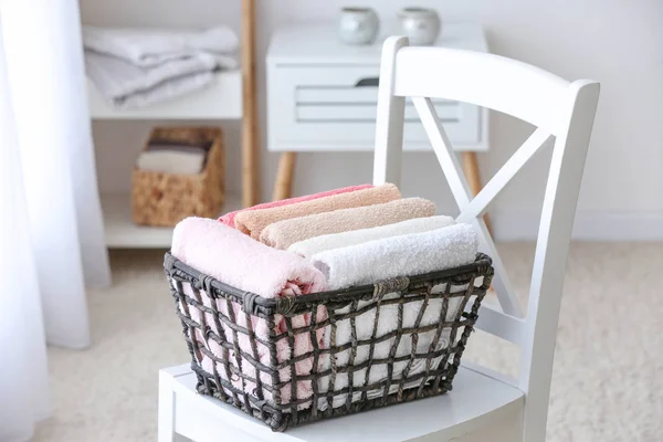 Cesta com toalhas macias limpas na cadeira no banheiro — Fotografia de Stock