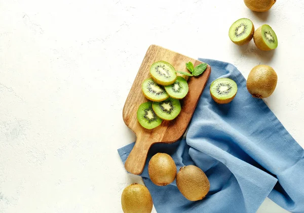 Board with tasty ripe kiwi on white background — Stock Photo, Image