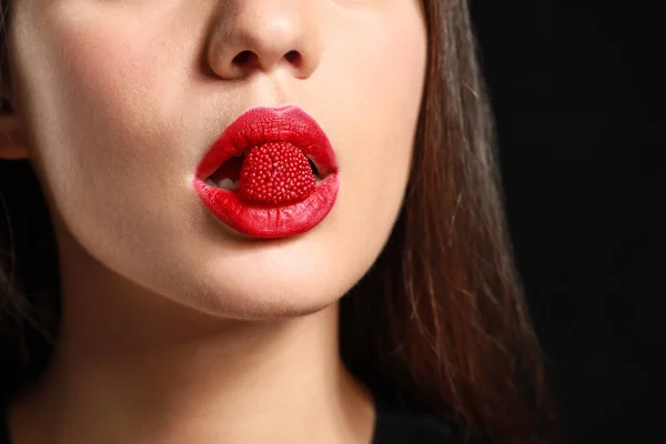 Beautiful young woman with candy in mouth, closeup — Stock Photo, Image