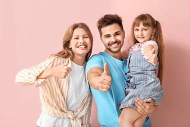 Mutlu aile portresi renk arka planda başparmak-up jest gösteren