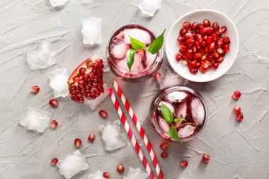 Gri arka planda soğuk nar suyu bardak