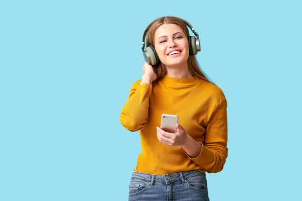 Mujer joven escuchando audiolibro sobre fondo de color — Foto de Stock