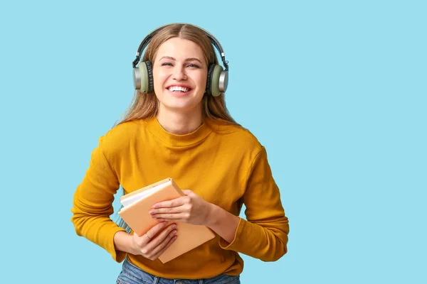 Young woman listening to audiobook on color background — Stock Photo, Image