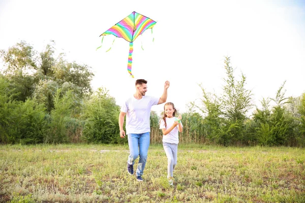 Ung man med liten dotter flygande kite utomhus — Stockfoto