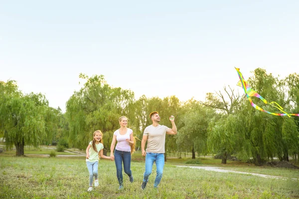 Happy family flying kite outdoors — Stock Photo, Image