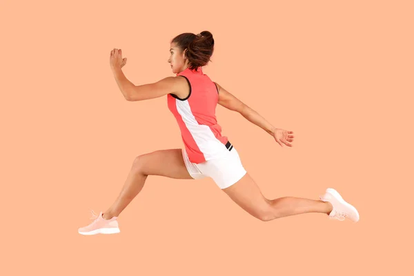 Running sporty woman on color background — Stock Photo, Image
