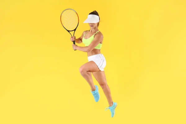 Прыжки теннисистки на цветном фоне — стоковое фото
