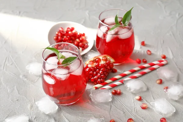 Glasses of cold pomegranate juice on grey background — Stock Photo, Image