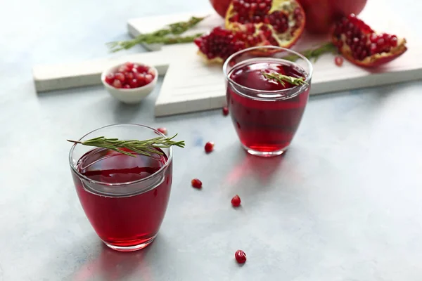Glasses of tasty pomegranate juice on table — Stock Photo, Image