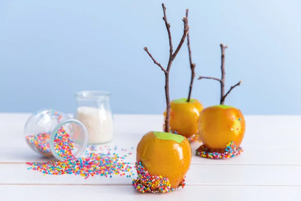 Tasty candy apples on white wooden table — Stock Photo, Image