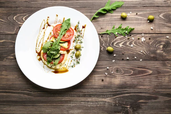 Bord met smakelijke salade op houten achtergrond — Stockfoto
