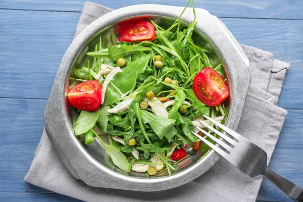 Prato com saborosa salada de rúcula em fundo de madeira — Fotografia de Stock