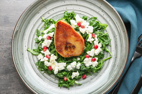 Plate with tasty arugula salad and pear on table — Stock Photo, Image