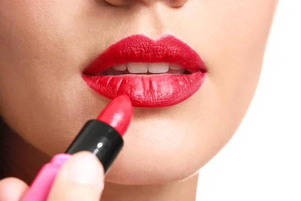 Mooie jonge vrouw aanbrengen van heldere lippenstift, close-up — Stockfoto