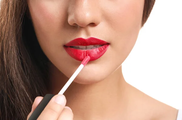 Bella giovane donna con rossetto su sfondo bianco, primo piano — Foto Stock