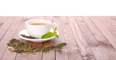 Beyaz arka plan karşı ahşap masada nane ile lezzetli çay Fincan