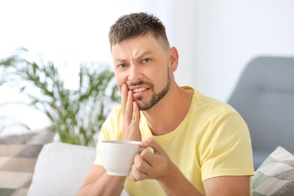 Homem com dentes sensíveis e café quente em casa — Fotografia de Stock