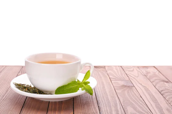 Cup of tasty tea with mint on wooden table against white background — Stock Photo, Image