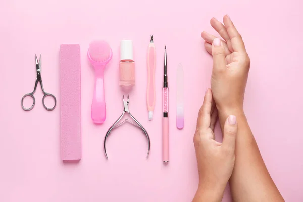 Mãos femininas com suprimentos para manicure no fundo de cor — Fotografia de Stock