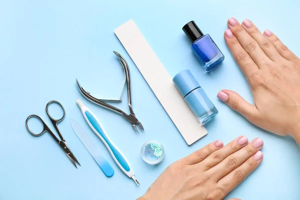 Manos femeninas con suministros para manicura sobre fondo de color — Foto de Stock