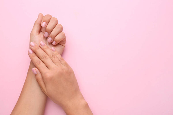 Женские руки с красивым маникюром на цветном фоне