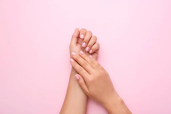 Manos femeninas con hermosa manicura sobre fondo de color — Foto de Stock