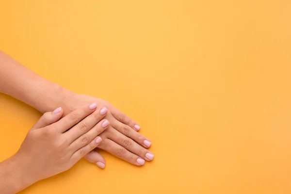 Mãos femininas com bela manicure no fundo de cor — Fotografia de Stock