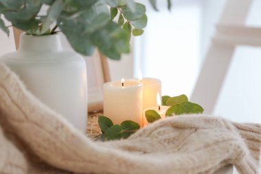 Masada okaliptüs dalları ile güzel yanan mumlar ve vazo