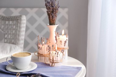 Bir fincan kahve, yanan mumlar ve odada masada lavanta