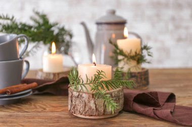 Kahve demliği, bardaklar ve masada yanan mumlar