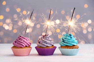 Defokus ışıkları karşı masada Lezzetli Doğum günü cupcakes