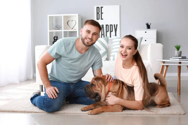 Счастливая пара с милой собакой дома — стоковое фото