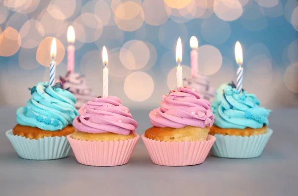 Välsmakande födelsedag cupcakes på bordet mot defokuserad ljus — Stockfoto