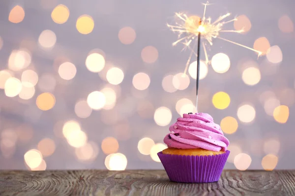 Smaczne urodziny Cupcake na stole przed rozmyte światła — Zdjęcie stockowe